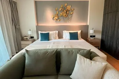 a bedroom with a large bed with blue and white pillows at 5 Star La Vita Studio Rawai 702 in Phuket Town
