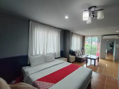a bedroom with a large bed and a living room at Madam Inn Patong in Patong Beach