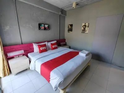 a bedroom with a large bed with red and white pillows at Madam Inn Patong in Patong Beach