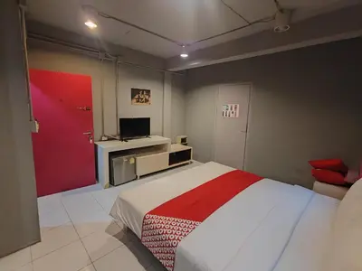 a bedroom with a bed and a tv in it at Madam Inn Patong in Patong Beach