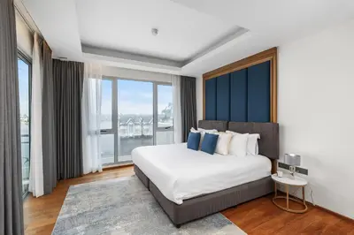 a bedroom with a bed and a large window at Beachfront 3BR Penthouse with Private Rooftop Pool - Laguna, BangTao in Phuket Town