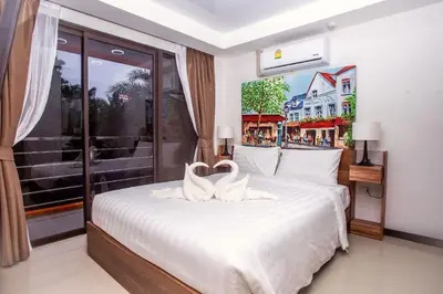 a bedroom with a bed with two white towels on it at Tropical Bliss, Relax & Enjoy at 1BR Apartment MBC near Mai Khao Beach! in Mai Khao Beach