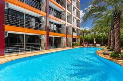 a large swimming pool in front of a building at Tropical Bliss, Relax & Enjoy at 1BR Apartment MBC near Mai Khao Beach! in Mai Khao Beach