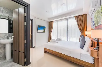 a bedroom with a bed and a sink and a window at Tropical Bliss, Relax & Enjoy at 1BR Apartment MBC near Mai Khao Beach! in Mai Khao Beach