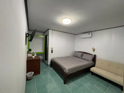 a small bedroom with a bed and a couch at Alanta aonang resort in Ban Khlong Haeng