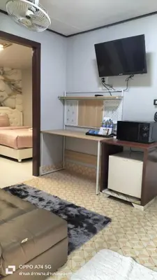 a living room with a desk with a tv on the wall at Alanta aonang resort in Ban Khlong Haeng