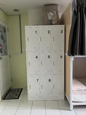 a bedroom with white lockers and a bed at Mawa Anle Hostel in Patong Beach
