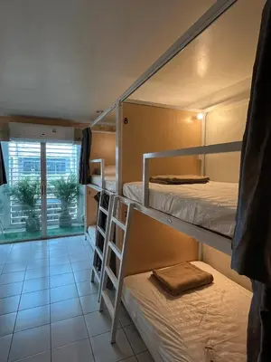 a dorm room with two bunk beds and a window at Mawa Anle Hostel in Patong Beach