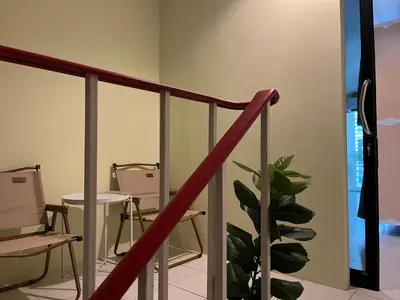 a staircase with chairs and a plant in a room at Mawa Anle Hostel in Patong Beach