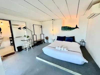 a bedroom with a large white bed with blue pillows at Patong seaview 2bedrooms white house in Patong Beach