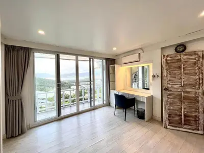 a living room with a desk and a large window at Patong seaview 2bedrooms white house in Patong Beach