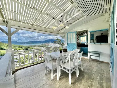 a dining room with a table and chairs on a balcony at Patong seaview 2bedrooms white house in Patong Beach