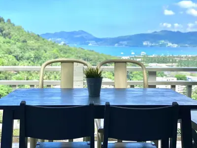a blue table with two chairs and a potted plant at Patong seaview 2bedrooms white house in Patong Beach