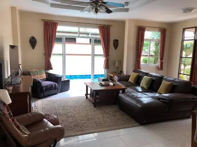 a living room with a leather couch and a table at Luxury Pool Villa by Golf Courses & Elephant Sanctuary in Kathu