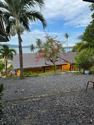 a house with palm trees in front of it at Baan Suan Sunset in Ban Laem Sai