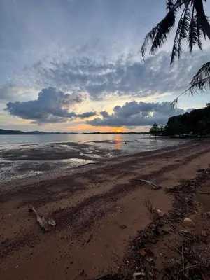 a sunset on a beach with the ocean at Baan Suan Sunset in Ban Laem Sai