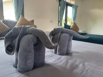 two stuffed elephants are sitting on a bed at Baan Suan Sunset in Ban Laem Sai