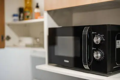 a black microwave on a counter in a kitchen at C201 Neatest Apartment The title 50m to beach and shops in Rawai Beach