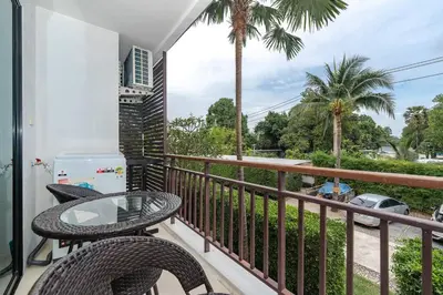 a balcony with a table and chairs and palm trees at C201 Neatest Apartment The title 50m to beach and shops in Rawai Beach