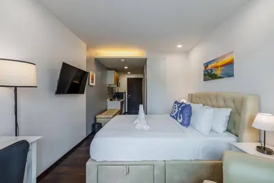 a bedroom with a large white bed and a couch at C201 Neatest Apartment The title 50m to beach and shops in Rawai Beach