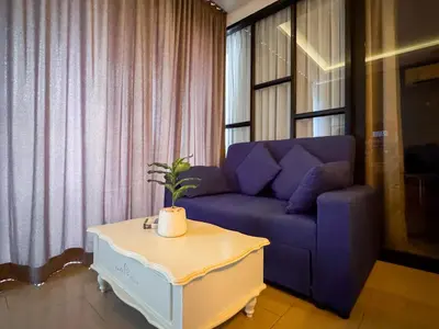 a living room with a purple couch and a table at Cozy 1BR Apartment with Big Balcony - 2 Pools & 5 mins from Surin Beach in Phuket Town