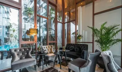 a restaurant with chairs and tables and windows at Cozy 1BR Apartment with Big Balcony - 2 Pools & 5 mins from Surin Beach in Phuket Town