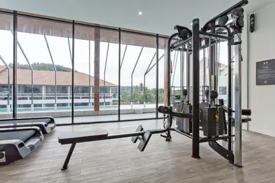 a room with a gym with a large window at Cozy 1BR Apartment with Big Balcony - 2 Pools & 5 mins from Surin Beach in Phuket Town