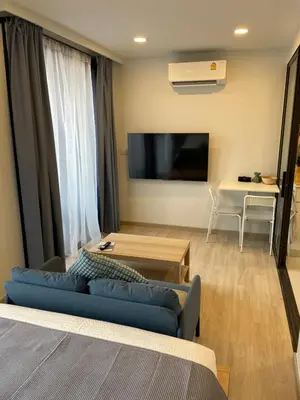 a living room with a blue couch and a flat screen tv at Studio Apartment, Bang Tao Phuket in Laguna Phuket