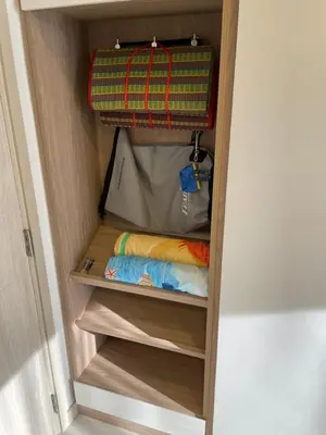 a small closet with wooden shelves and a suitcase at Studio Apartment, Bang Tao Phuket in Laguna Phuket