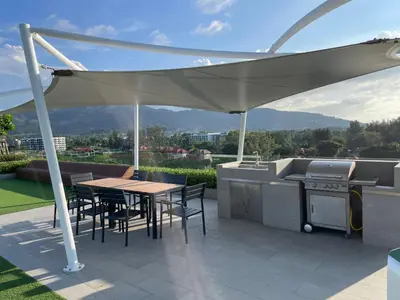 a patio with a grill and a table and chairs at Studio Apartment, Bang Tao Phuket in Laguna Phuket