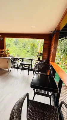 a porch with chairs and tables and a large window at Brightstar Hostel in Phi Phi Don