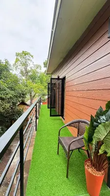 a porch with a bench and green grass at Brightstar Hostel in Phi Phi Don