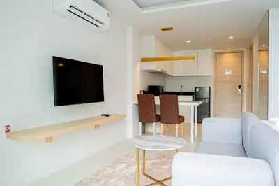 a living room with a couch and a tv on a wall at Karen Sunset Hotel in Phuket Town