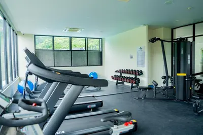 a gym with a bunch of tread machines in it at Karen Sunset Hotel in Phuket Town