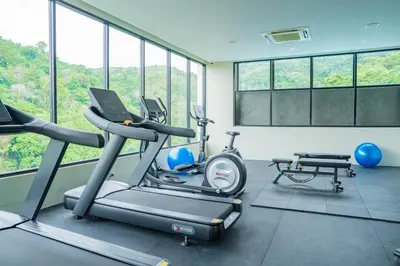 a gym with two exercise bikes and a laptop at Karen Sunset Hotel in Phuket Town