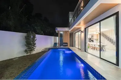a swimming pool in front of a house at night at V149 La bella villa Brand New Fully Luxury in Bang Tao Beach