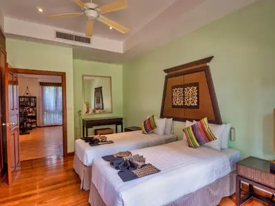 a bedroom with two beds and a ceiling fan at Happy villa in Laguna in Layan Beach