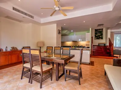 a dining room with a table and chairs and a kitchen at Happy villa in Laguna in Layan Beach