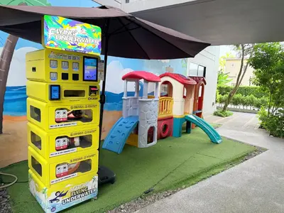 a playground with a video game machine and an umbrella at Diamond Resort Phuket Condo Bang Tao Beach in Thalang