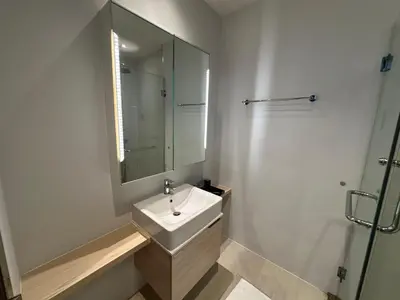 a white bathroom with a sink and a mirror at Diamond Resort Phuket Condo Bang Tao Beach in Thalang