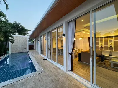 an external view of a house with glass doors and a patio at The Sense Villa Phuket in Rawai Beach