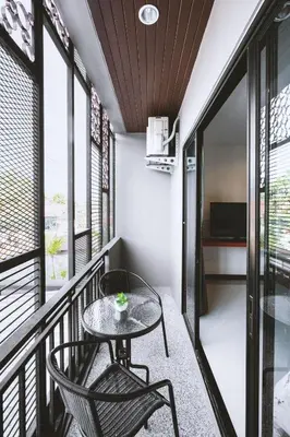 a balcony with a table and chairs and windows at Ra Residence Phuket in Chalong
