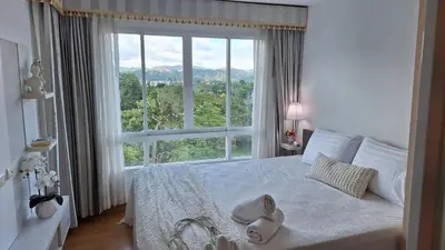a bedroom with a bed with a large window at Plus condo 2 kathu by Tida in Kathu