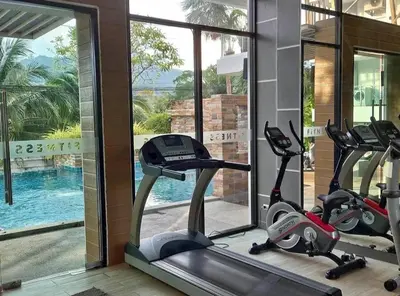 a gym with three exercise bikes in front of a window at Plus condo 2 kathu by Tida in Kathu