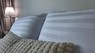 a bed with two blue and white pillows on it at Plus condo 2 kathu by Tida in Kathu
