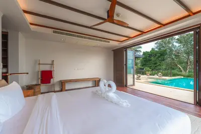 a bedroom with a large bed and a swimming pool at V151 Nicest Villa With The Best Views In Phuket in Thalang