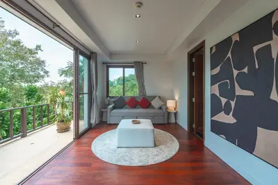 a living room with a couch and a balcony at V151 Nicest Villa With The Best Views In Phuket in Thalang