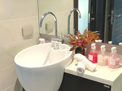 a bathroom with a white sink and a mirror at Emerald Terrace Serenity 11 - 5th Floor Garden View by PSR in Patong Beach