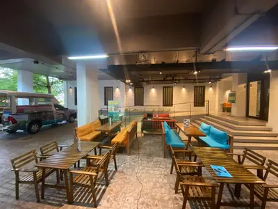 a restaurant with wooden tables and blue chairs at Emerald Terrace Serenity 11 - 5th Floor Garden View by PSR in Patong Beach