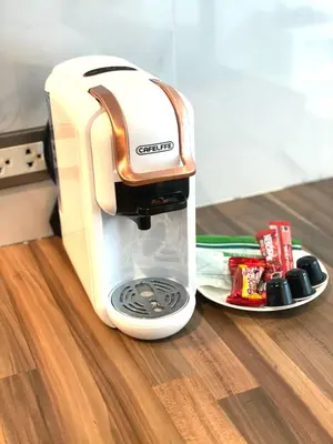 a coffee maker sitting on a table next to a plate at Emerald Terrace Serenity 11 - 5th Floor Garden View by PSR in Patong Beach